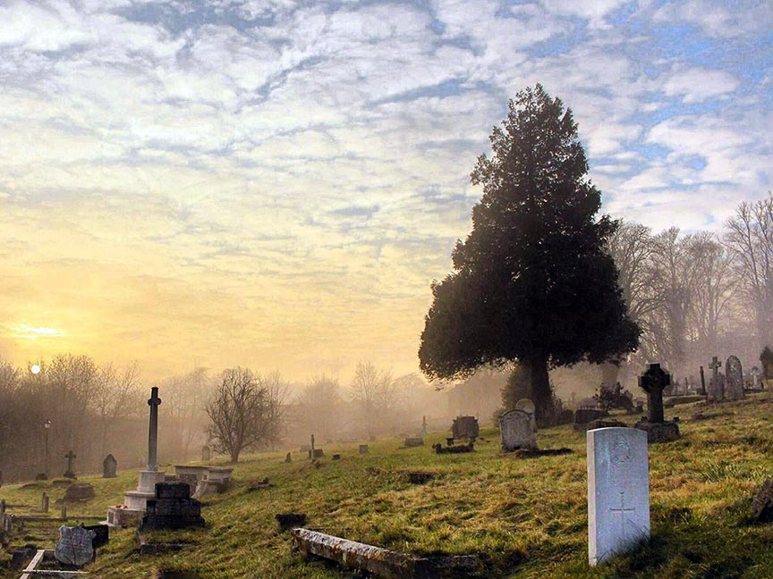 Cemetery at dawn in Saratoga County, NY showing beautiful sunrise over cemetery.