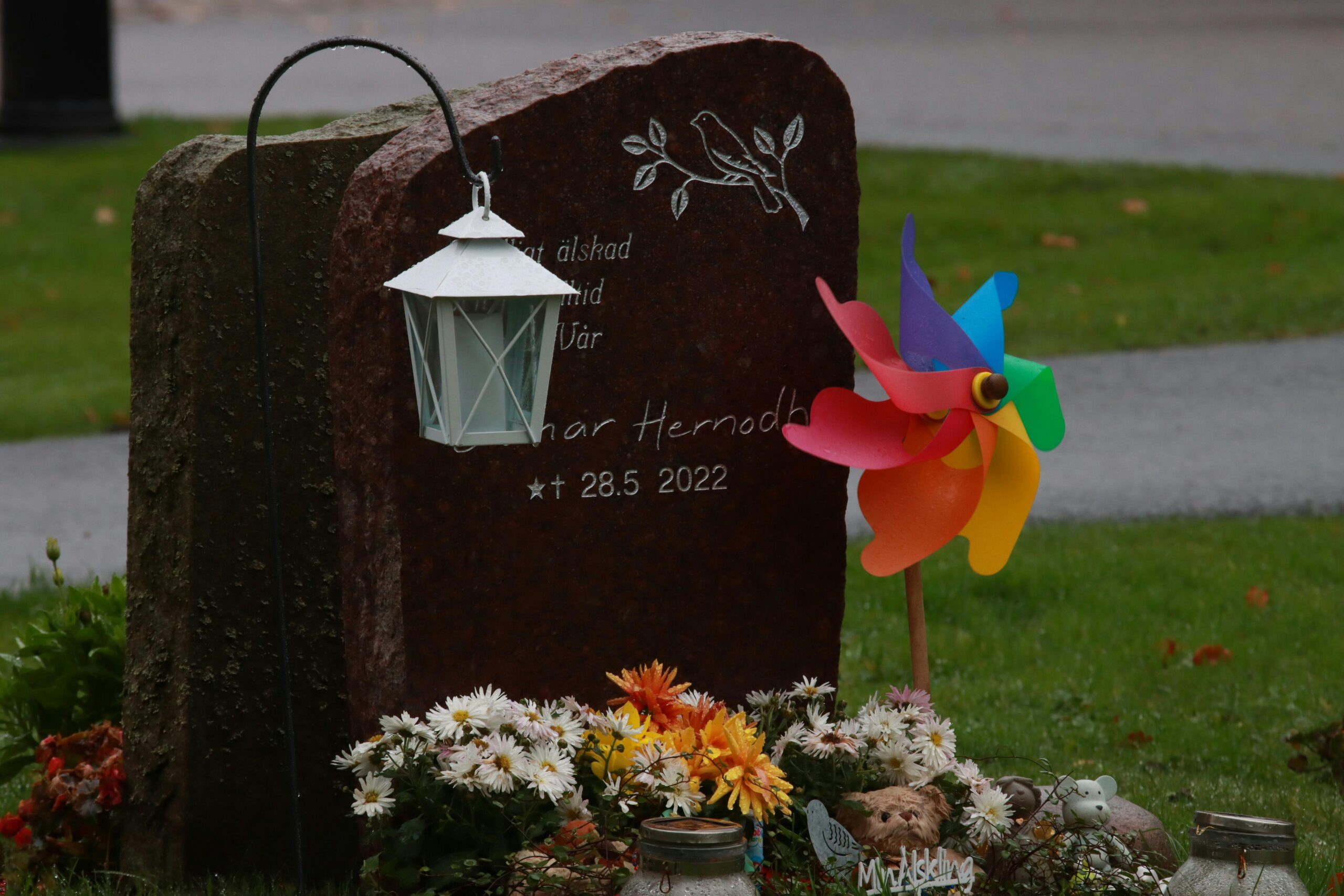 Common gravesite decorations including flowers, flags, wreaths, and seasonal arrangements displayed respectfully at a cemetery.
