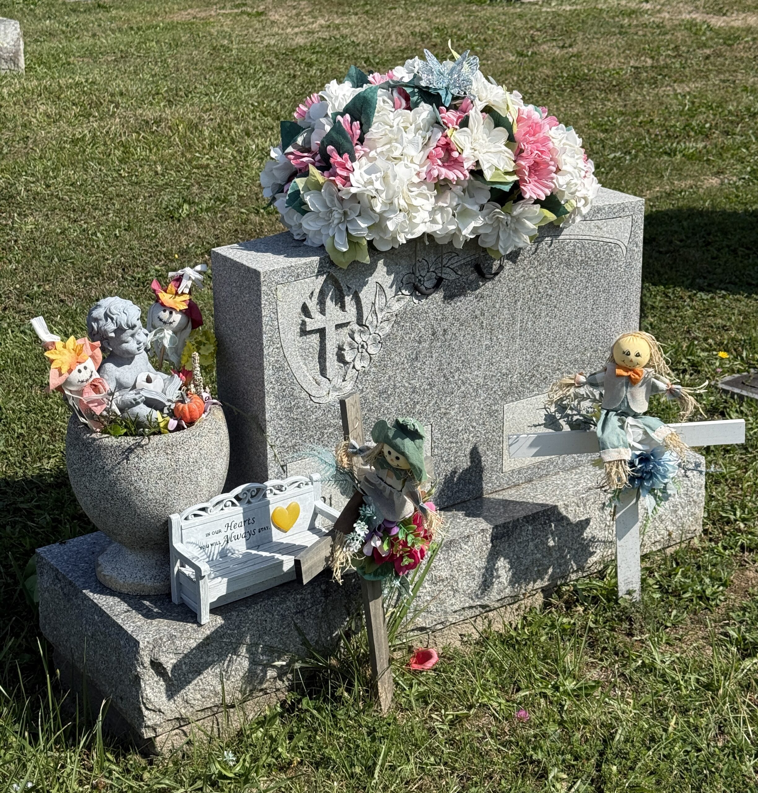 Memorial decorations arranged neatly at a gravesite, representing respectful cemetery-appropriate ways to decorate a grave.