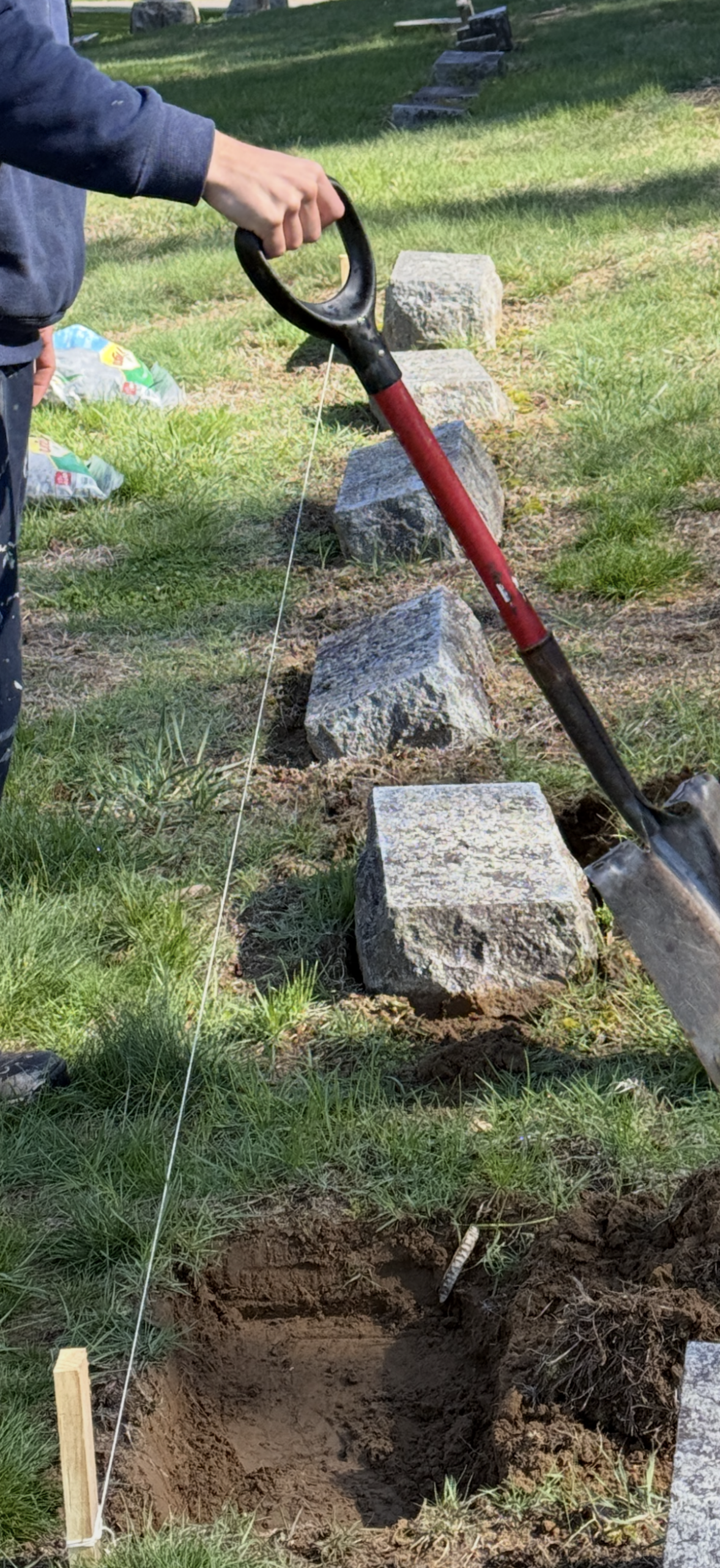 Cemetery memorial repair and reset work in progress at a family plot
