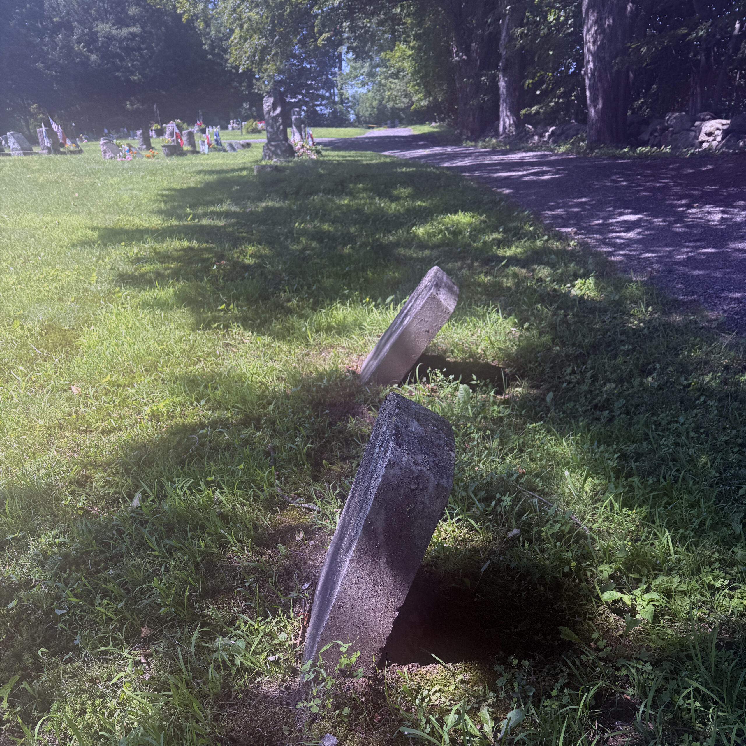 Leaning gravestones requiring stabilization and cemetery preservation attention