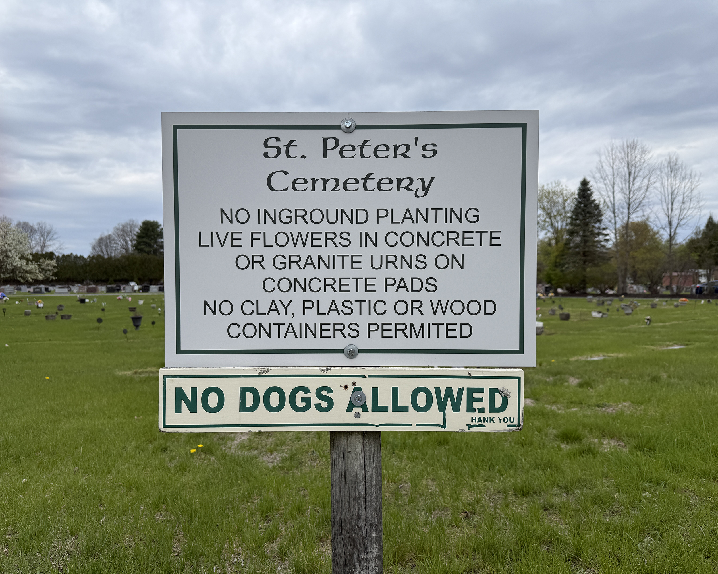 St. Peter’s Cemetery rules sign in Saratoga Springs NY showing regulations for flowers, containers, and cemetery guidelines.