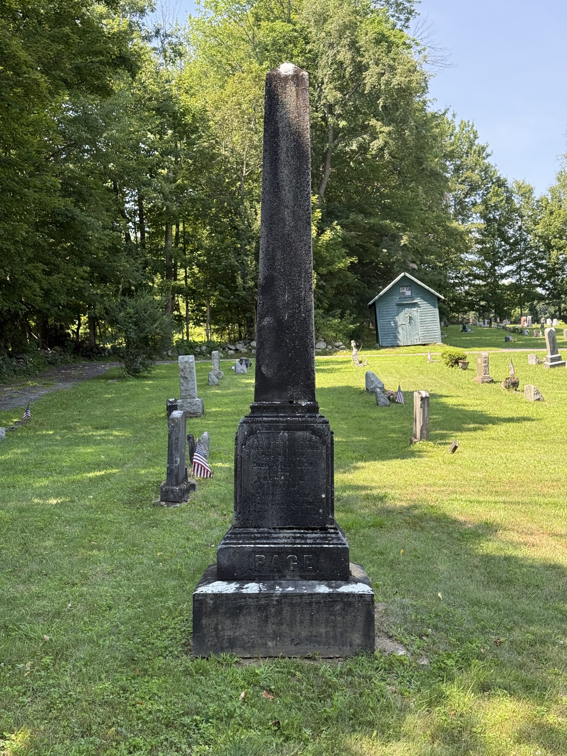 Black streaking and staining on a cemetery obelisk monument