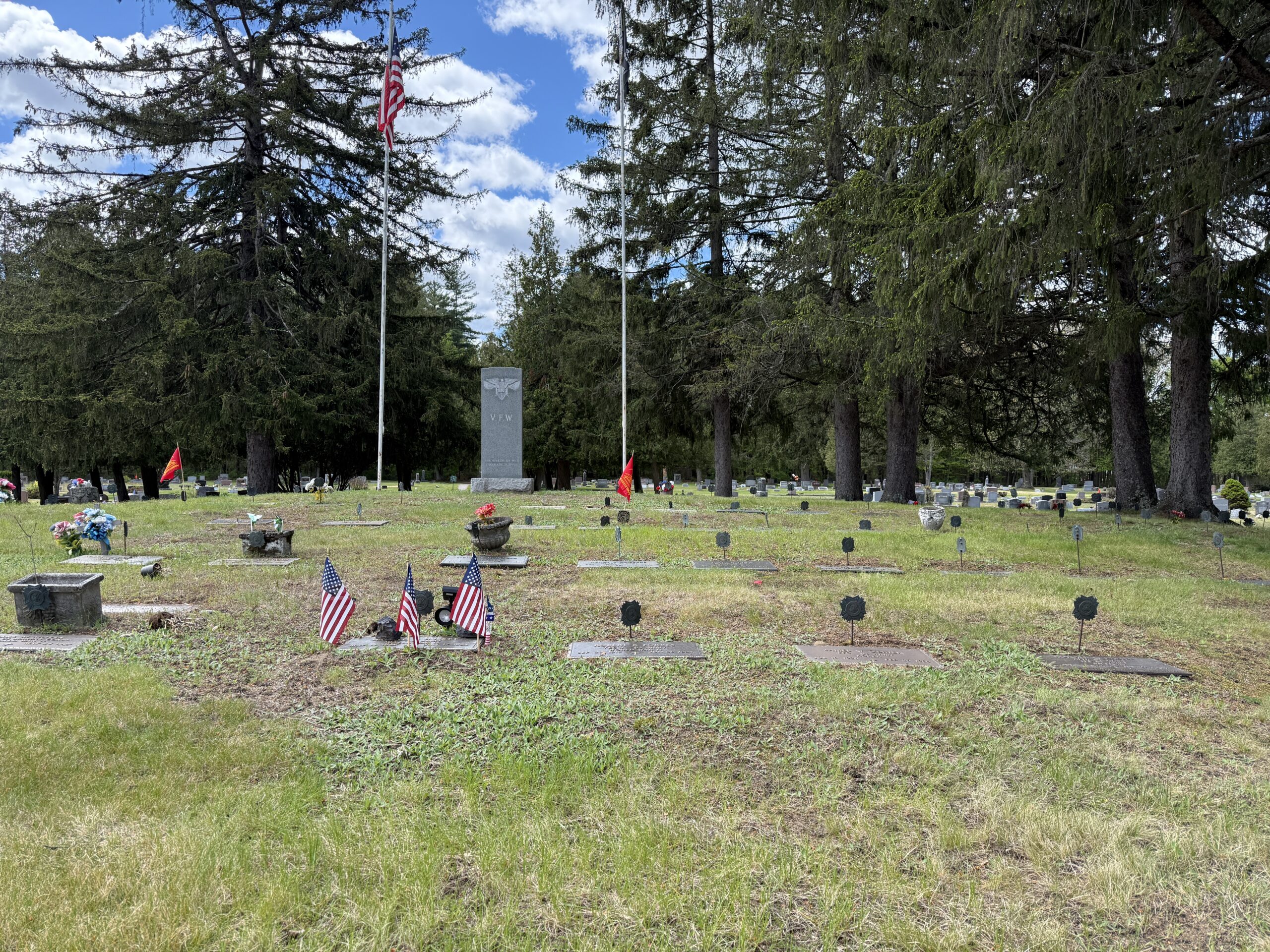 Veterans section at Maplewood Cemetery with American flags and veteran grave markers